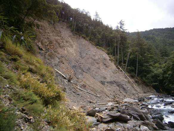 More landslide aftermath along the riverbank.